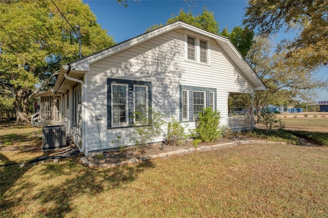 view of side of property with cooling unit and a lawn