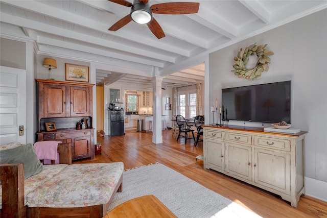 living room with decorative columns, ceiling fan, beam ceiling, and light wood-type flooring