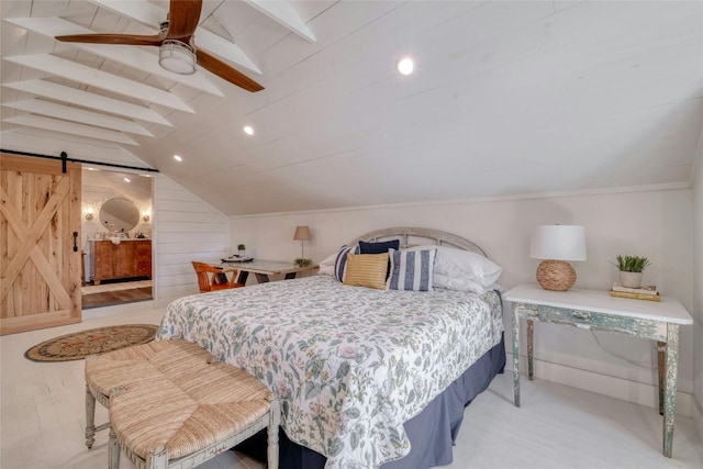 bedroom featuring vaulted ceiling with beams, a barn door, light hardwood / wood-style flooring, and ceiling fan