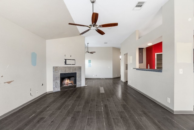 unfurnished living room featuring a tile fireplace, dark hardwood / wood-style floors, and ceiling fan