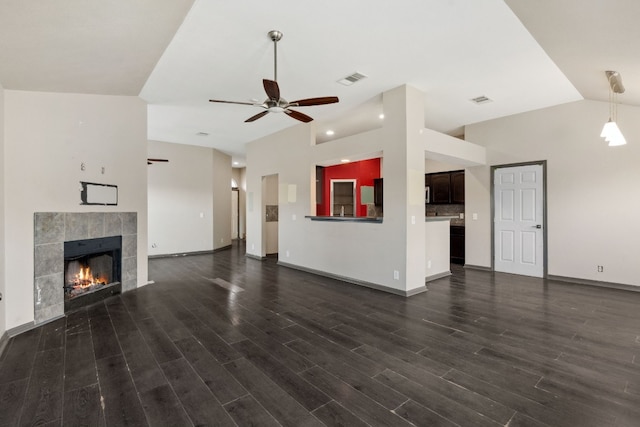 unfurnished living room with a fireplace, dark hardwood / wood-style floors, and ceiling fan