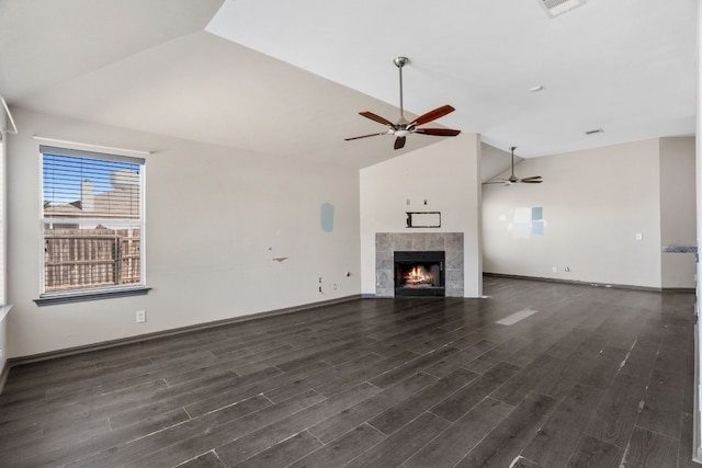 unfurnished living room with high vaulted ceiling, dark hardwood / wood-style floors, ceiling fan, and a tile fireplace