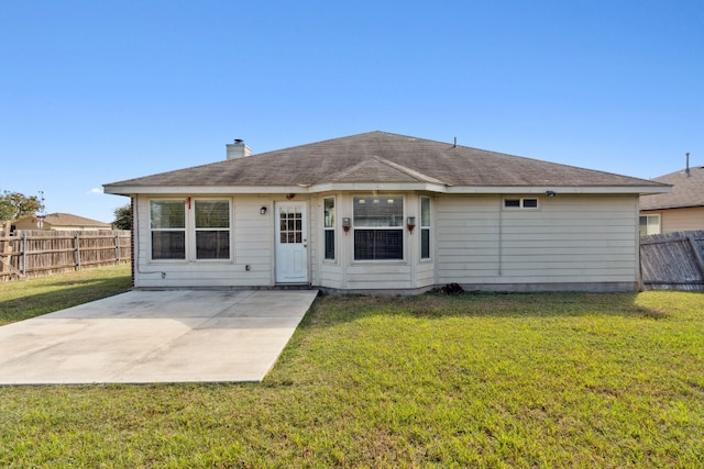 rear view of property with a lawn and a patio area