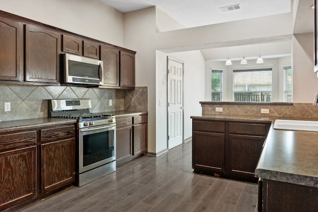 kitchen with dark hardwood / wood-style flooring, dark brown cabinetry, stainless steel appliances, sink, and decorative light fixtures