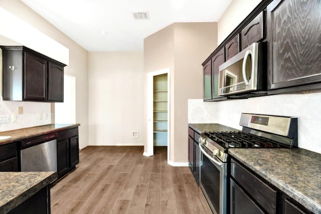 kitchen with decorative backsplash, light hardwood / wood-style flooring, stainless steel appliances, and dark brown cabinets