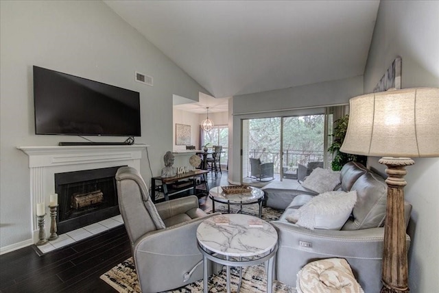 living room with hardwood / wood-style floors, an inviting chandelier, and lofted ceiling