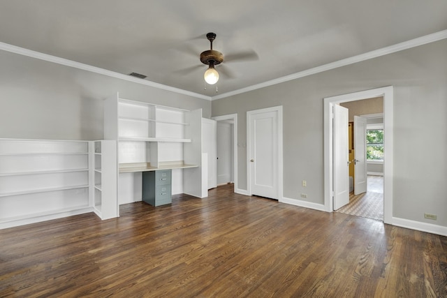 unfurnished bedroom with ceiling fan, dark hardwood / wood-style flooring, built in desk, and crown molding