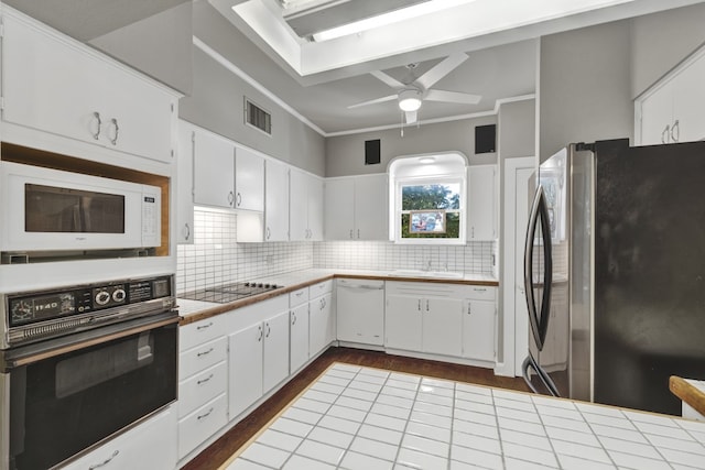 kitchen featuring black appliances, white cabinetry, ornamental molding, and tile countertops