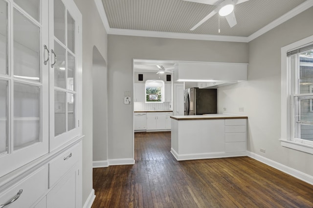 kitchen featuring dark hardwood / wood-style flooring, ceiling fan, crown molding, white cabinetry, and stainless steel refrigerator