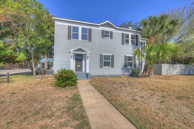 view of front of home with cooling unit and a front lawn