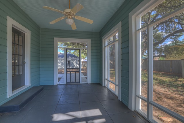 unfurnished sunroom with ceiling fan