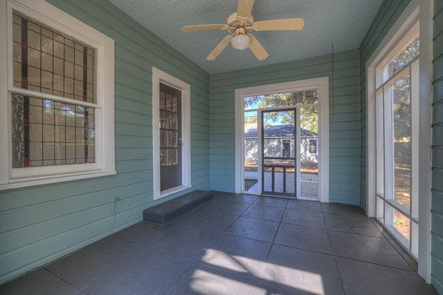 unfurnished sunroom with ceiling fan