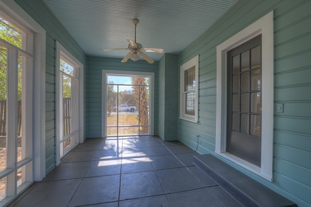 unfurnished sunroom with ceiling fan