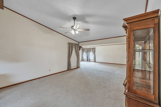 811 Ross Cir, Lockhart, TX 78644 - spare room with vaulted ceiling, crown molding, carpet, a textured ceiling, and ceiling fan