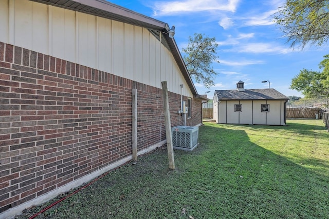 view of yard featuring central AC and a storage shed