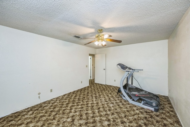 workout room featuring carpet flooring, ceiling fan, and a textured ceiling