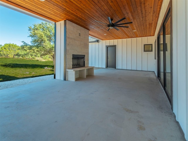 view of patio with ceiling fan and a large fireplace