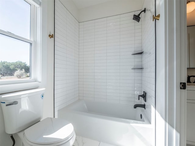 bathroom featuring tiled shower / bath combo and toilet