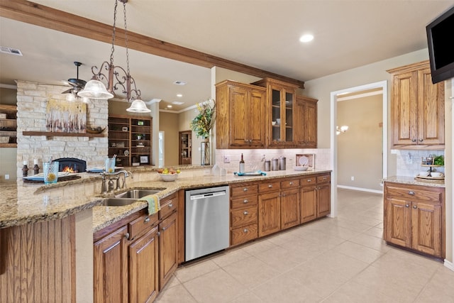 kitchen with pendant lighting, dishwasher, sink, light stone countertops, and tasteful backsplash