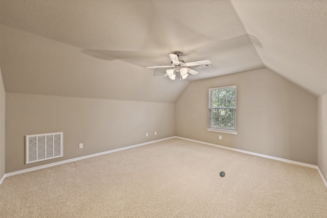 additional living space featuring carpet flooring, ceiling fan, a textured ceiling, and vaulted ceiling