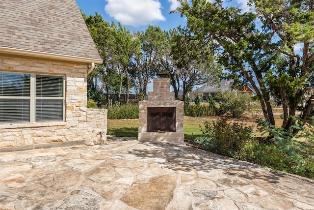 view of patio / terrace featuring an outdoor stone fireplace