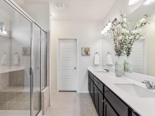 bathroom featuring tile patterned floors, a shower with door, and vanity