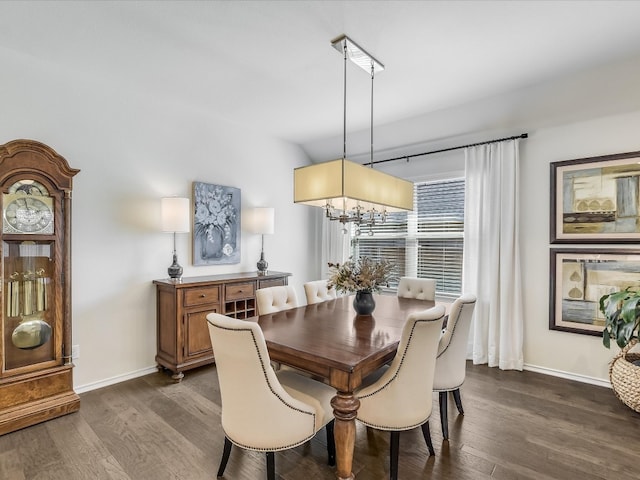 dining room with dark hardwood / wood-style floors and an inviting chandelier