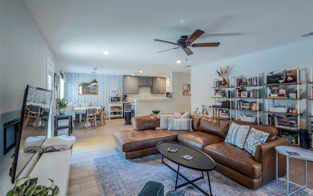 living room featuring light hardwood / wood-style flooring and ceiling fan