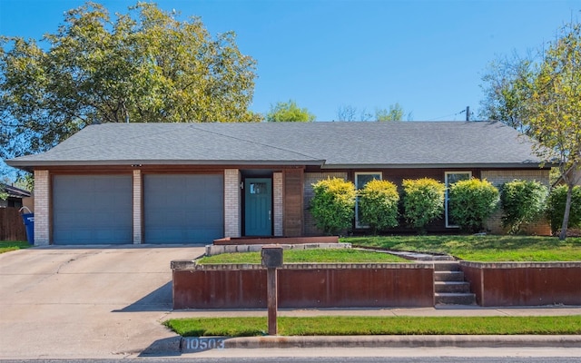 ranch-style home with a garage and a front lawn