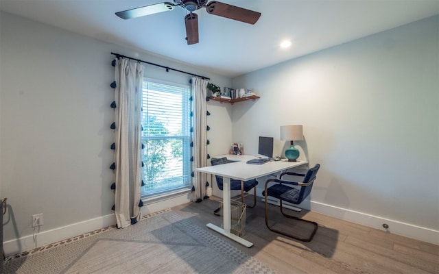 office with light wood-type flooring and ceiling fan