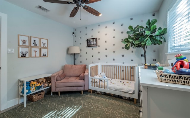 bedroom featuring a crib and ceiling fan