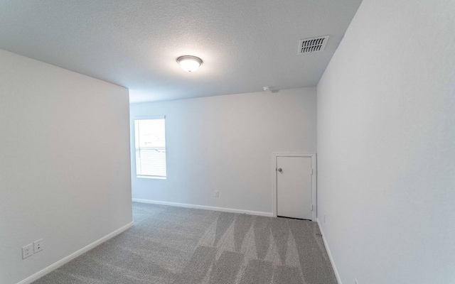 unfurnished room featuring carpet and a textured ceiling