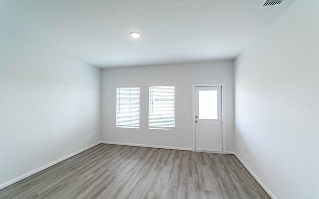 unfurnished room with light hardwood / wood-style flooring and a wealth of natural light