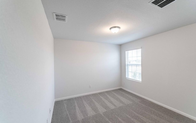 unfurnished room featuring carpet floors and a textured ceiling