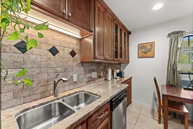 kitchen featuring sink, light stone counters, stainless steel dishwasher, crown molding, and decorative backsplash