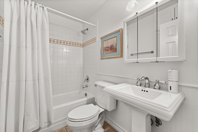 bathroom with tile patterned floors, shower / tub combo with curtain, and toilet