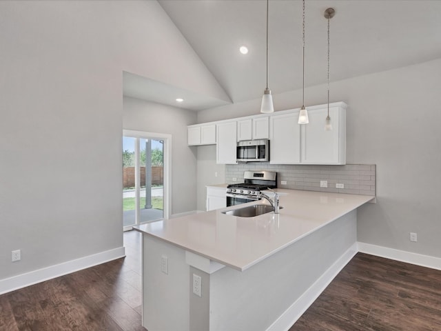 kitchen featuring kitchen peninsula, white cabinetry, pendant lighting, and appliances with stainless steel finishes