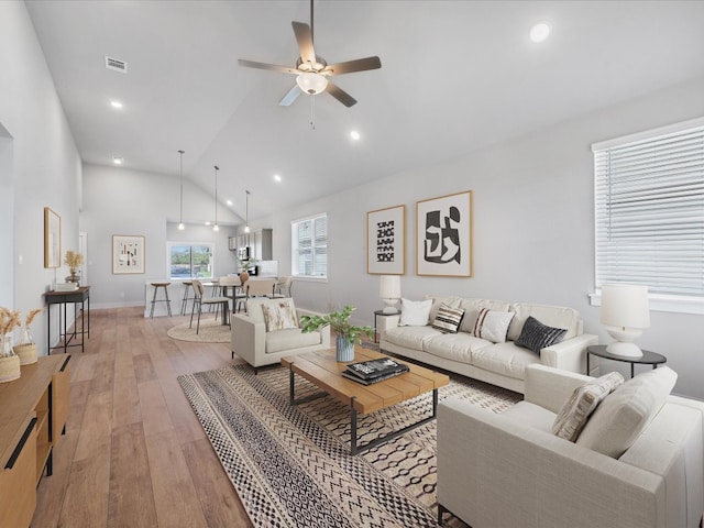 living room featuring ceiling fan, light wood-type flooring, and high vaulted ceiling