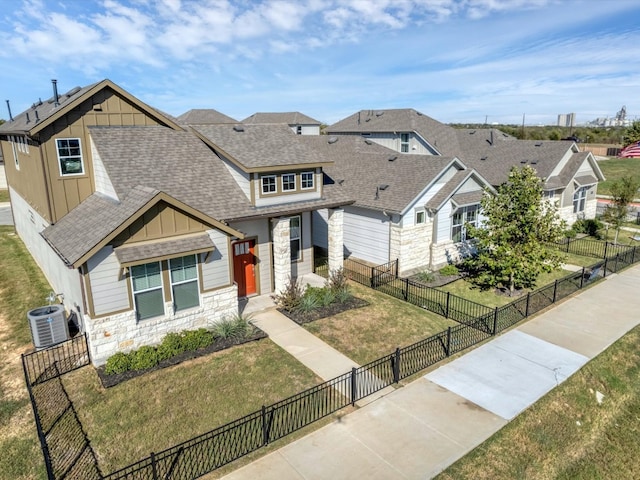 craftsman-style house with central air condition unit and a front yard