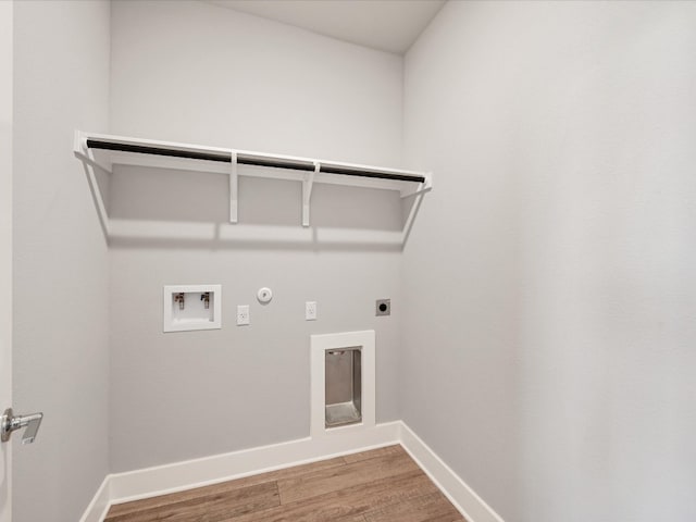 clothes washing area with hardwood / wood-style floors, hookup for an electric dryer, gas dryer hookup, and washer hookup