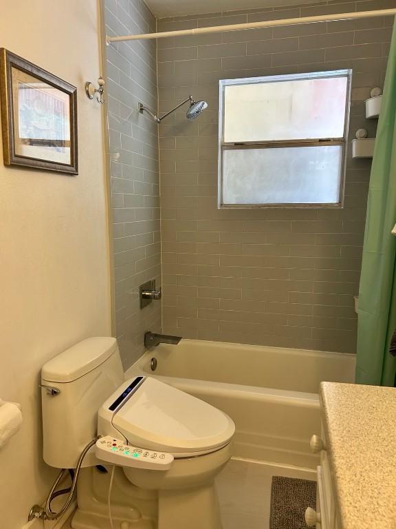 full bathroom featuring tile patterned flooring, shower / bath combination with curtain, vanity, and toilet