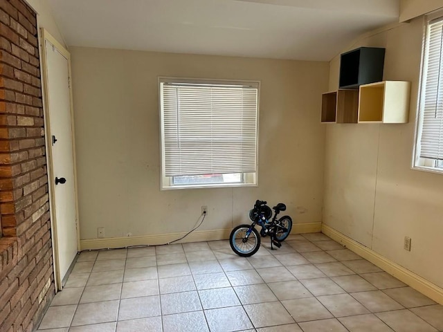 spare room with light tile patterned floors and a healthy amount of sunlight