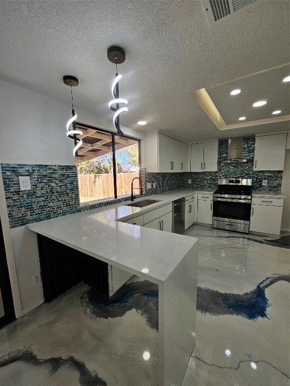 kitchen featuring pendant lighting, backsplash, sink, stainless steel range oven, and white cabinetry