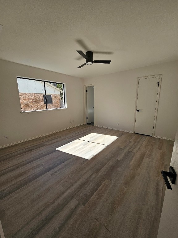 unfurnished room with ceiling fan, dark hardwood / wood-style flooring, and a textured ceiling