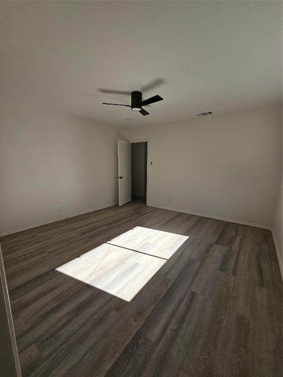 unfurnished room featuring ceiling fan and dark wood-type flooring