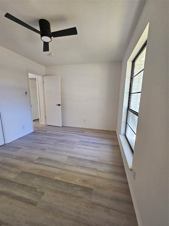 spare room featuring hardwood / wood-style flooring, ceiling fan, and a wealth of natural light