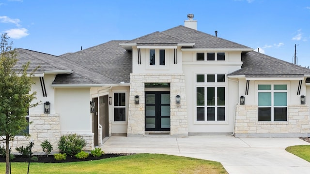 back of property with french doors and a lawn