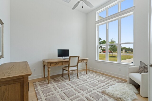 home office featuring ceiling fan, light hardwood / wood-style floors, and a wealth of natural light