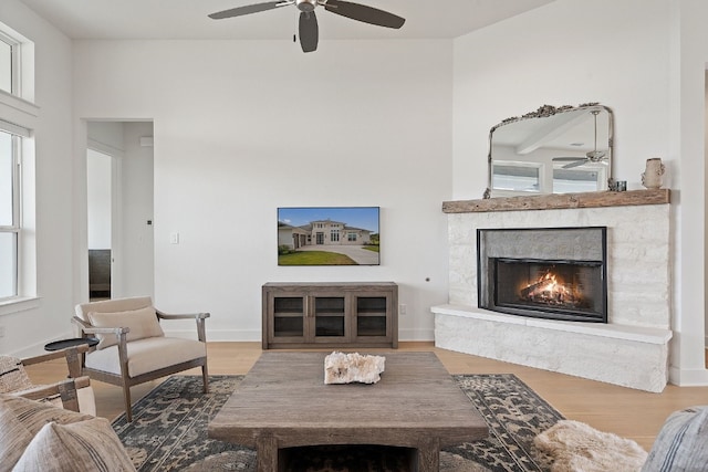 living room featuring hardwood / wood-style floors, a premium fireplace, and ceiling fan