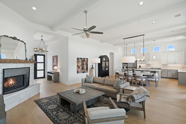 301 Miranda Way, Georgetown, TX 78633 - living area featuring light wood-style floors, beamed ceiling, recessed lighting, a premium fireplace, and ceiling fan